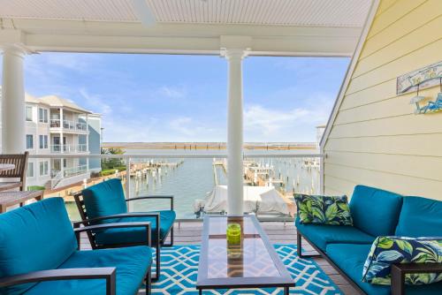 a porch with blue furniture and a view of the water at Sunset Bay Villa 209 in Chincoteague
