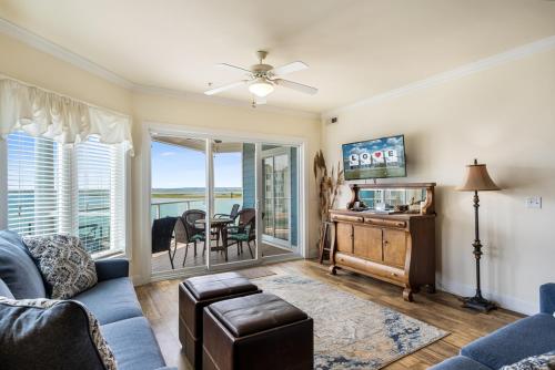 a living room with a couch and a table with a view at Sunset Bay Villa 216 in Chincoteague