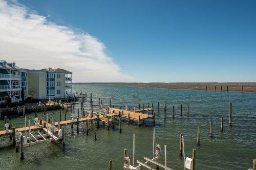 a dock in the water next to a building at Sunset Bay Villa 216 in Chincoteague