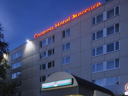 a building with a neon sign on the side of it at Congress Hotel Mercure Nürnberg an der Messe in Nuremberg