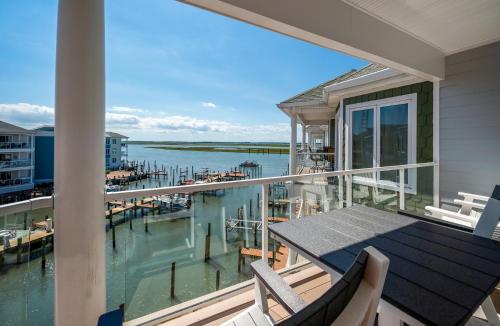 a balcony with a table and chairs and a marina at Sunset Bay Villa 313 - By the Bay in Chincoteague