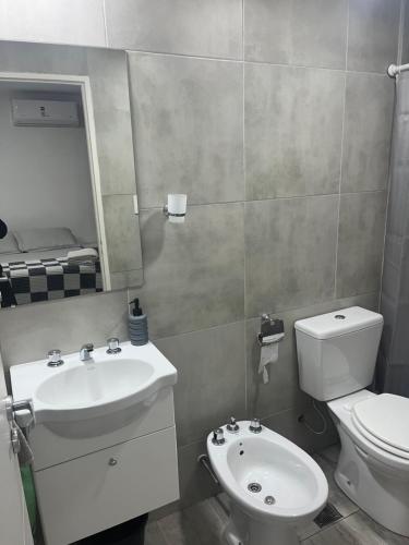 a bathroom with a sink and a toilet and a mirror at Depto temporal in Morón