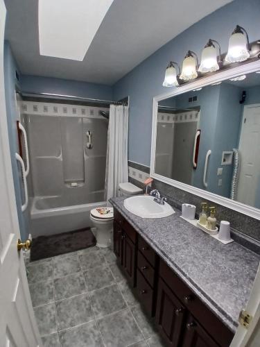 a bathroom with a sink and a toilet and a mirror at Home Away From Home in Moncton