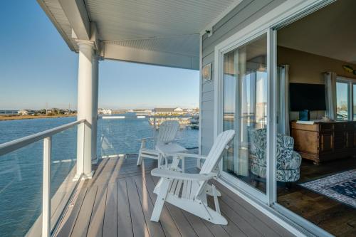 a porch with two chairs and a table on the water at Sunset Bay Villa 319 - Bella Vista in Chincoteague