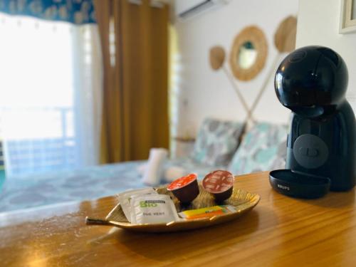 a plate of food on a table next to a coffee maker at Hibis Gold in Cayenne