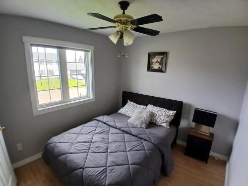 a bedroom with a bed and a ceiling fan at Home Away From Home in Moncton