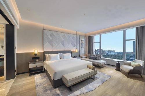 a bedroom with a large bed and a large window at Crowne Plaza Rugao in Nantong