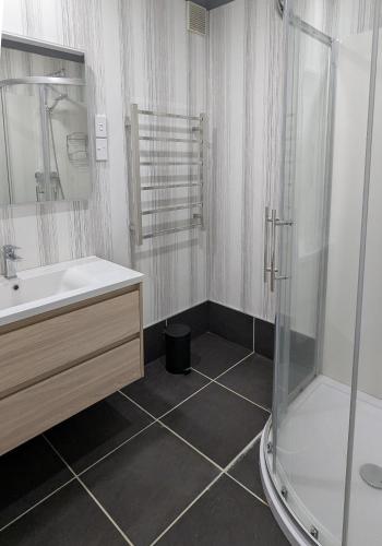 a bathroom with a shower and a sink at Miro St Guest House in Mount Maunganui