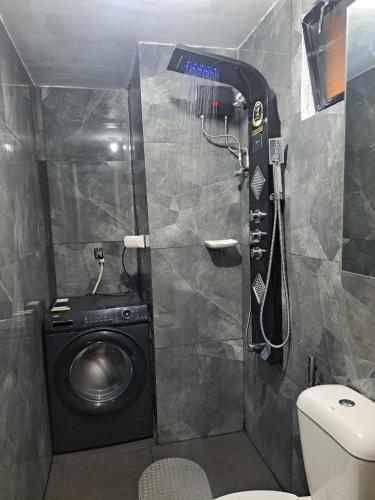 a bathroom with a washing machine and a toilet at Royal oceancrest mactan in Mactan Island
