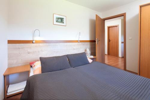 a bedroom with a blue bed and a wooden wall at Holiday Park Orava Bungalows in Dolný Kubín