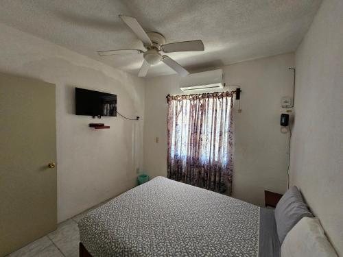 a bedroom with a bed and a ceiling fan at Departamento Playa Linda in Barrio Nuevo