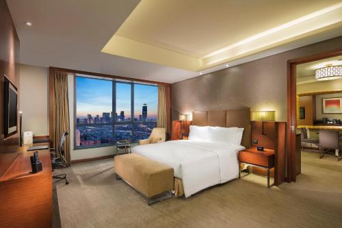 ein Schlafzimmer mit einem großen Bett und einem großen Fenster in der Unterkunft DoubleTree by Hilton Shenyang in Shenyang