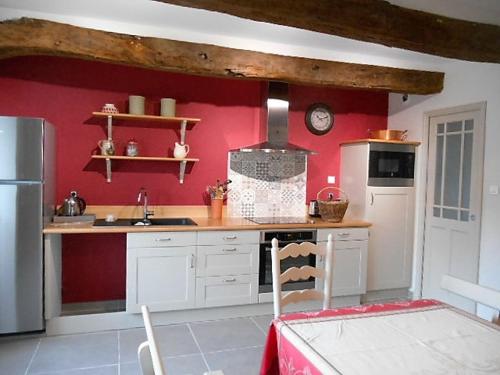 a kitchen with red walls and a counter top at Le Logis de Tréonvel in Locmélar