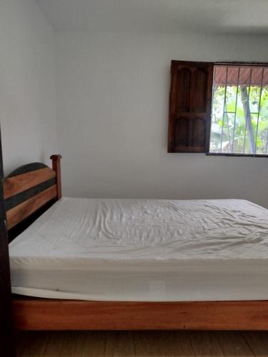 a bed in a bedroom with a window at Milflora casa completa in Nuquí