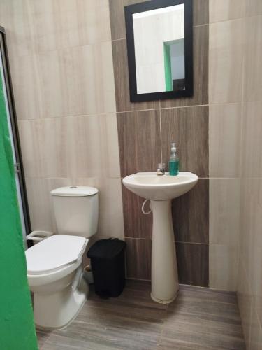 a bathroom with a toilet and a sink at Milflora casa completa in Nuquí