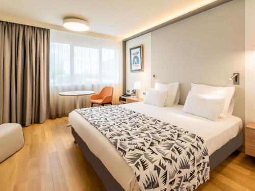 a hotel room with a large bed and a window at Mercure Marseille Centre Prado Vélodrome in Marseille