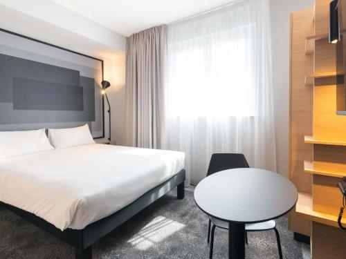 a hotel room with a bed and a table at ibis Strasbourg Centre Gare in Strasbourg