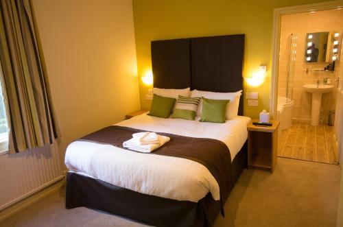 a bedroom with a large bed with a large headboard at Wakefield Limes Lodge in Wakefield