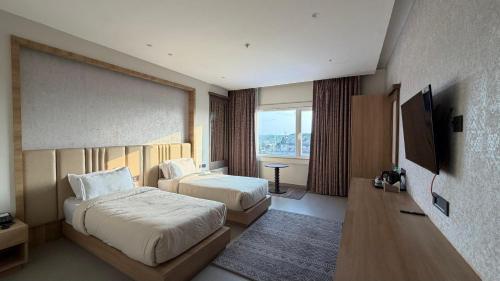 a hotel room with two beds and a flat screen tv at Hotel skyline by RK in Tinsukia