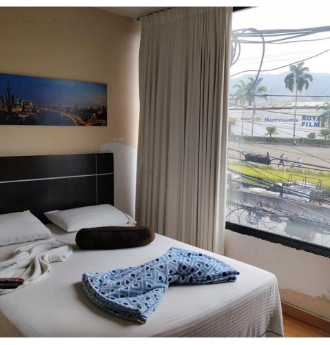 a bedroom with two beds and a large window at Hotel Platino Plaza in Dosquebradas