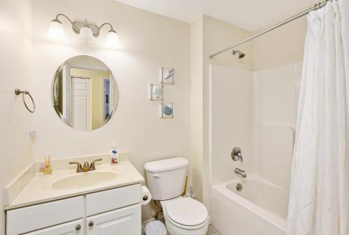 a bathroom with a toilet and a sink and a mirror at The Sweets Spot in Greenbackville