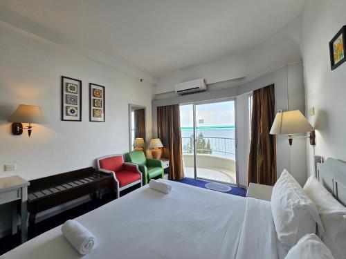 a hotel room with a bed and a living room at Paradise by the Sea in Penang by Veron at Rainbow Paradise in Tanjung Bungah