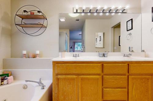 a bathroom with two sinks and a tub and a mirror at 1 Mi to Lake Tulloch: Home w/ Patio Oasis & Pool in Copper Cove Subdivision