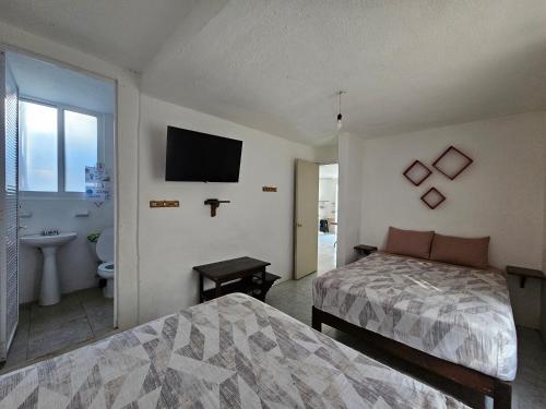 a bedroom with a bed and a bathroom with a television at Departamento en la Huertas in Barrio Nuevo