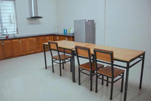 a kitchen with a wooden table and four chairs at Tám bảy in Cửa Lô