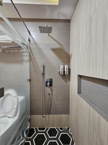 ein Badezimmer mit Dusche, Toilette und Waschbecken in der Unterkunft Serenity Beach Hotel in Puerto Galera