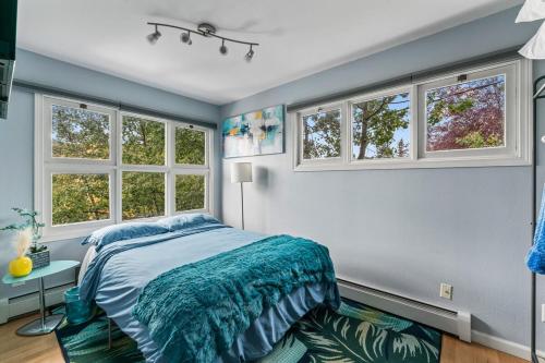 a bedroom with a bed and three windows at Close To Airport - Shared Space - Fast WI-FI in Anchorage