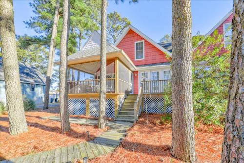 a red house with a porch in the woods at Whispering Pines in Black Point Landing