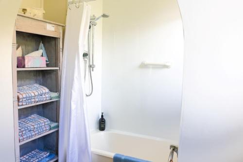 a bathroom with a shower curtain and a bath tub at Seaview Apartment in Picton