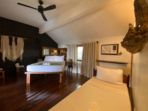 a bedroom with a bed and a ceiling fan at Happiness Boutique Resort El Nido in El Nido