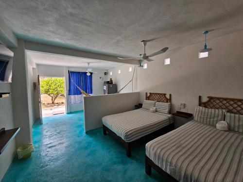 a bedroom with two beds and a couch and a window at Departamento Turquesa in Barrio Nuevo