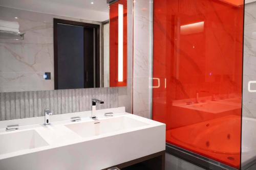 a bathroom with a white sink and a red shower at Radisson Red Funes in Rosario