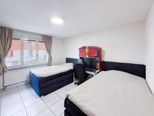 a room with two beds and a desk in it at Einfamilienhaus in Amriswil in Amriswil