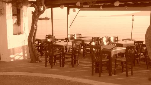 eine Gruppe von Tischen und Stühlen auf einer Terrasse in der Unterkunft O Fotis in Agios Prokopios