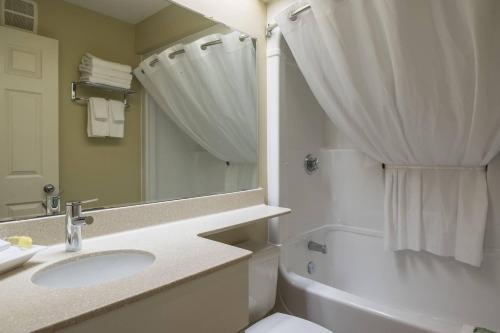 a bathroom with a sink and a toilet and a tub at Amsterdam Inn & Suites, an Ascend Collection Hotel in Moncton