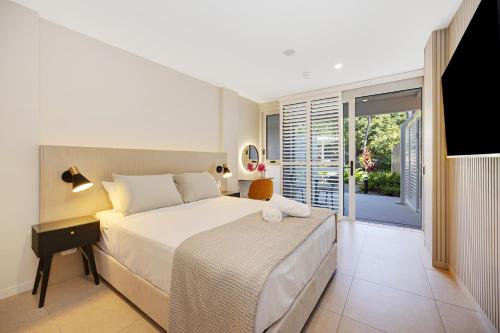 a bedroom with a bed and a sliding glass door at Picnic Bay Hotel in Picnic Bay