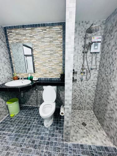 a bathroom with a toilet and a sink and a shower at Thalang Home in Thalang