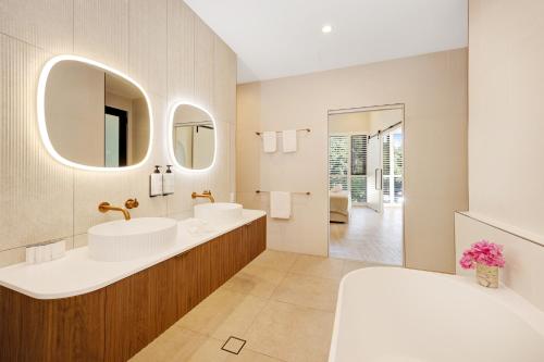 a bathroom with two sinks and a large mirror at Picnic Bay Hotel in Picnic Bay