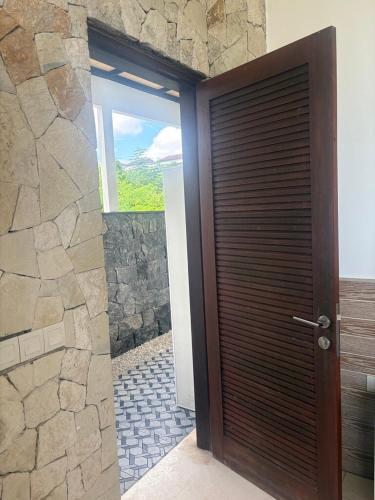 a wooden door in a room with a stone wall at NEW, Modern 1BR with Pool-Kitchen-Workspace-100Mb in Badung