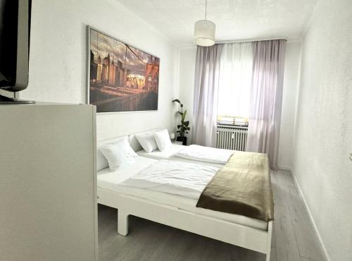 a white bedroom with a bed in a room at Refugium 2020 in Marienheide