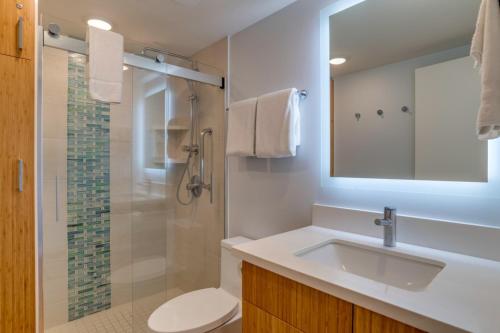 a white bathroom with a sink and a shower at The Hale Pau Hana in Kihei