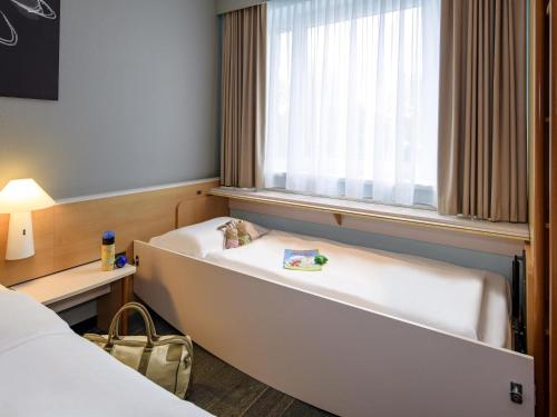a room with two beds and a window at ibis Hamburg Alsterring in Hamburg