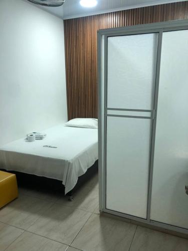 a bedroom with a bed and a sliding glass door at Casa Hotel Ortiz in Apartadó