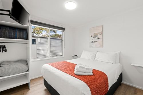a white bedroom with a bed and a window at Ingenia Holidays Torquay Australia in Torquay