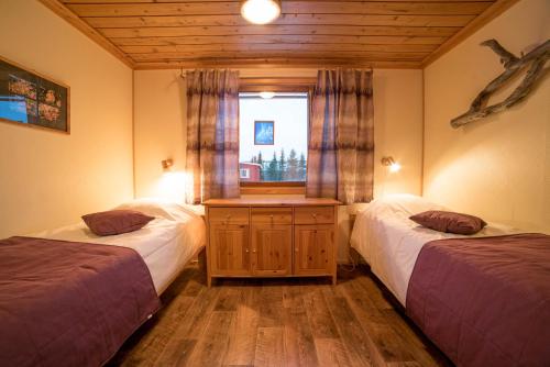a bedroom with two twin beds and a window at Ylläksen Yöpuu in Äkäslompolo