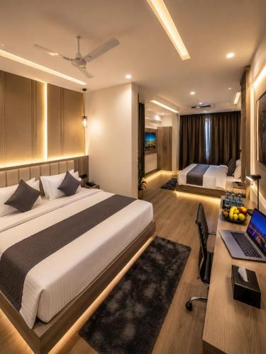 a bedroom with a bed and a desk with a laptop at ZED Plaza in New Delhi